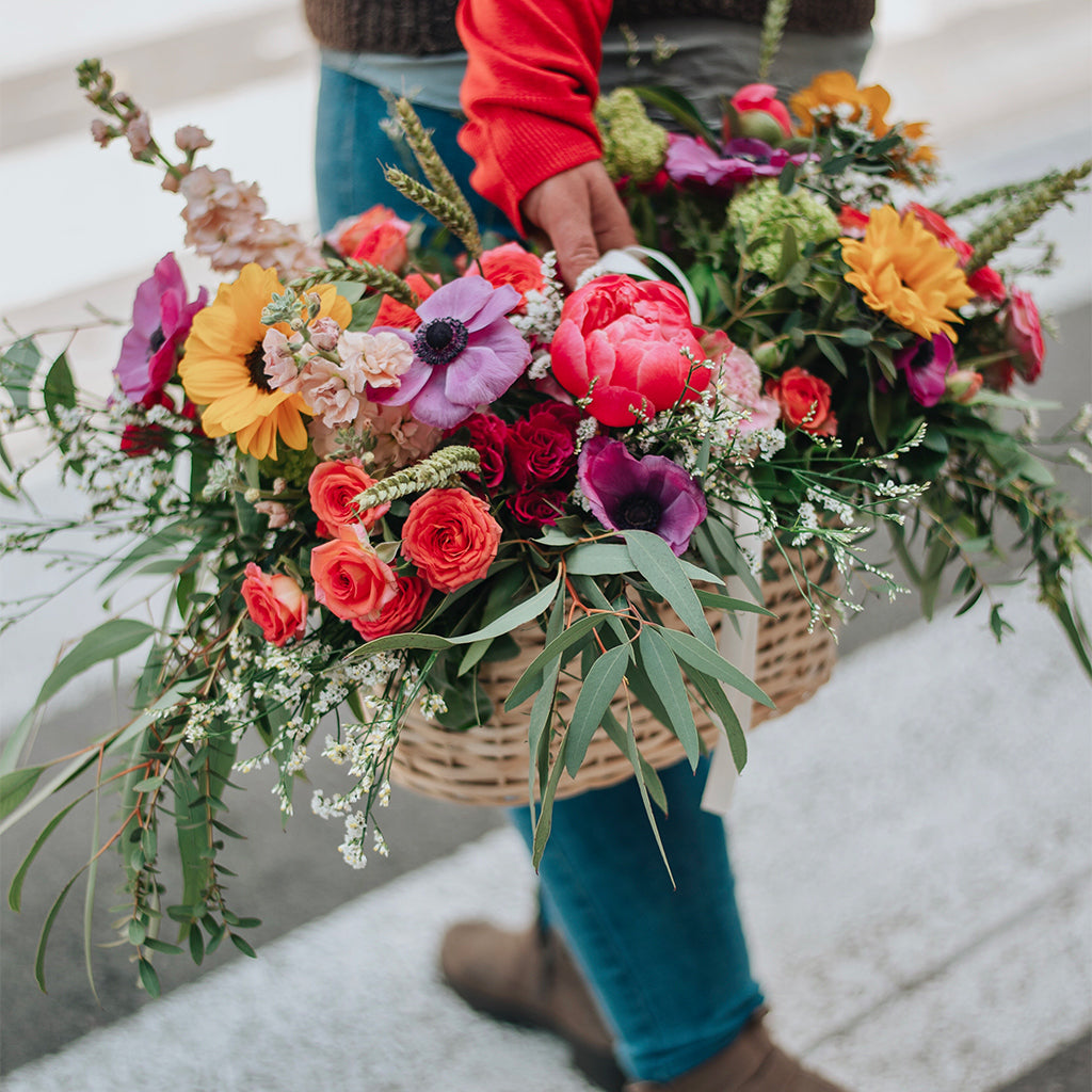 Cesto de picnic con flores de temporada