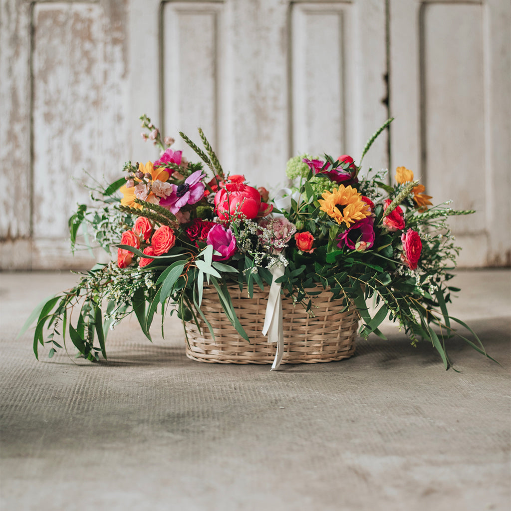 Cesto de picnic con flores de temporada